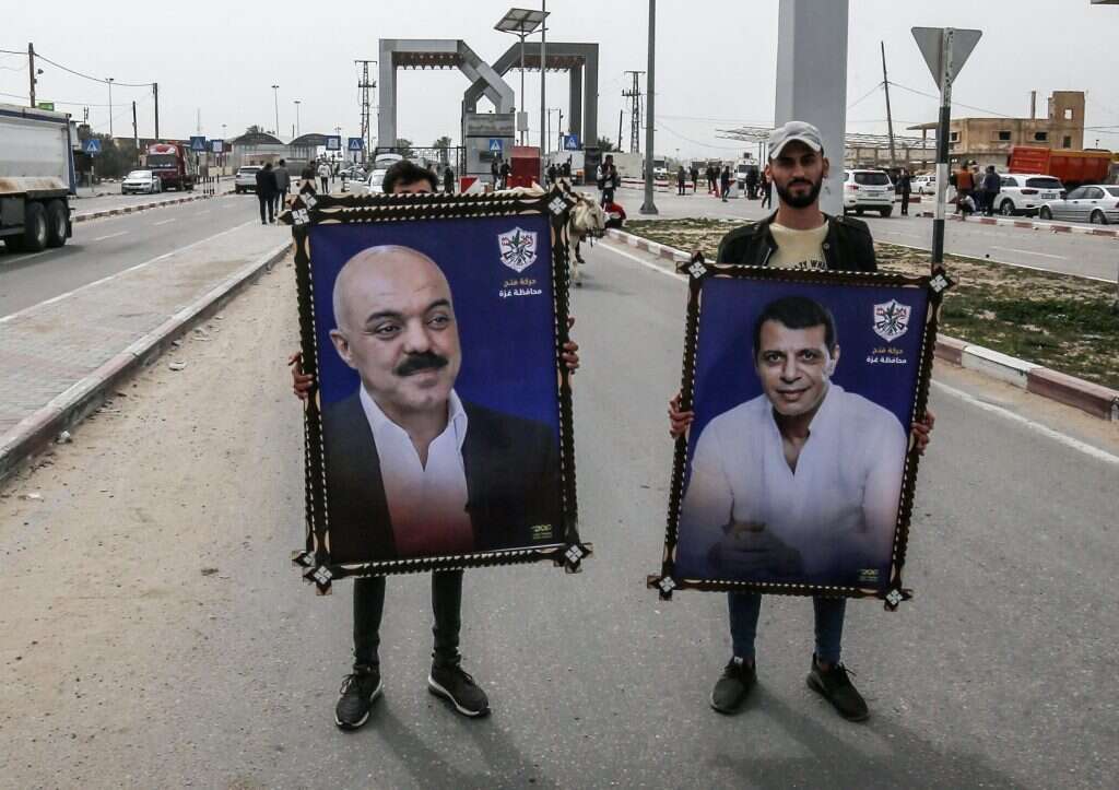 תמונתו של דחלאן (מימין) נישאת בידי פסלטיני ברצועה. | AFP