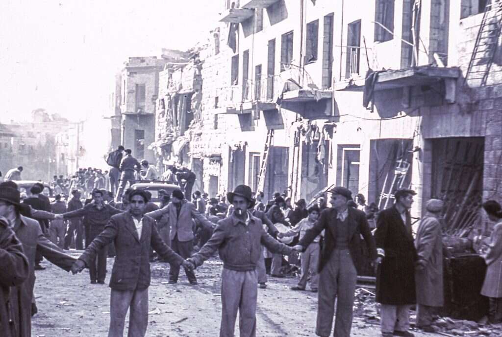 סדר למופת. מתנדבי המשמר מאפשרים את עבודות ההצלה ברחוב בן־יהודה לאחר הפיגוע שם, פברואר 1948. | מרלן לוין, אוסף מיתר, האוסף הלאומי לתצלומים ע"ש משפחת פריצקר, הספרייה הלאומית