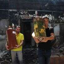 הוצאת ספר תורה מבית כנסת שרוף בלוד, אתמול. | EPA