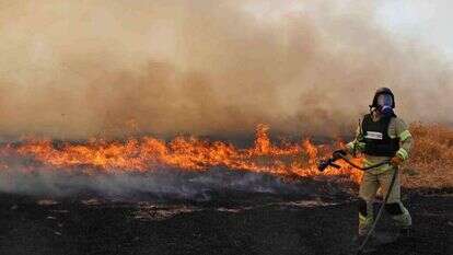 לוחמי האש מכבים שריפה שנגרמה עקב נפילת טיל. | AFP