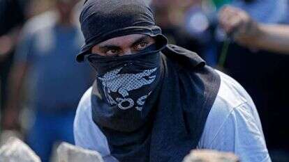 מתפרע פלסטיני מתעמת עם חיילי צה"ל סמוך לרמאללה. | AFP