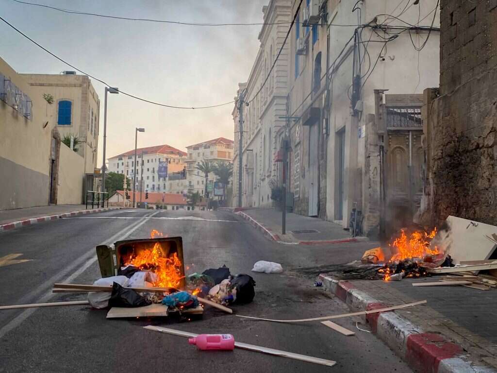 "אמרנו 'יהיה בסדר', בלי להבין מה באמת קורה". פח אשפה
בוער במהלך ההתפרעויות הערביות ביפו בחודש שעבר. | אבשלום ששוני - פלאש 90