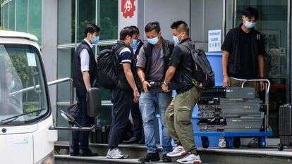 הרשויות מוציאות ציוד ומחשבים מבניין מערכת העיתון. | AFP