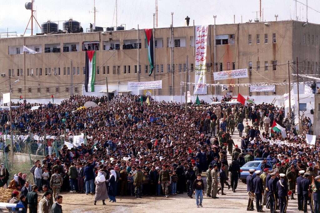פלסטינים חוגגים מול בניין הממשל בחברון לאחר שהשליטה בעיר נמסרה לידי הרשות הפלסטינית, ינואר  1997. | גטי אימג'ס