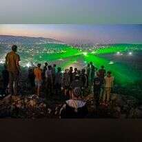 תושבי אביתר מביטים במפגינים פלסטינים, שמכוונים לעברם קרני לייזר. | AFP
