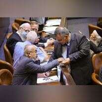 רגע של הפסקת אש בעיצומו של עימות אינסופי: ח"כ דוד ביטן מחלק סוכריות לעמיתיו במליאה, אתמול. | נועם מושקוביץ - דוברות הכנסת