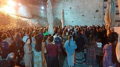 בנות מתפללות לצד המחיצות בכותל השוויוני