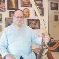 לואיס בביתו ב־ 2013 עם כינורות המשחזרים את כלי הנגינה במקדש