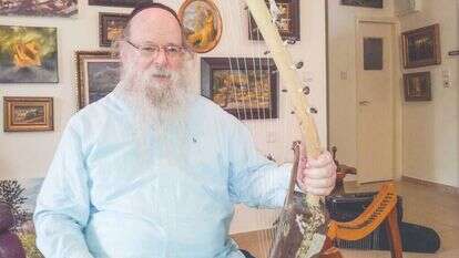 לואיס בביתו ב־ 2013 עם כינורות המשחזרים את כלי הנגינה במקדש