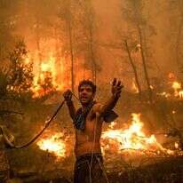 תושב האי אוויה מסייע למאמצי כיבוי האש. | AFP