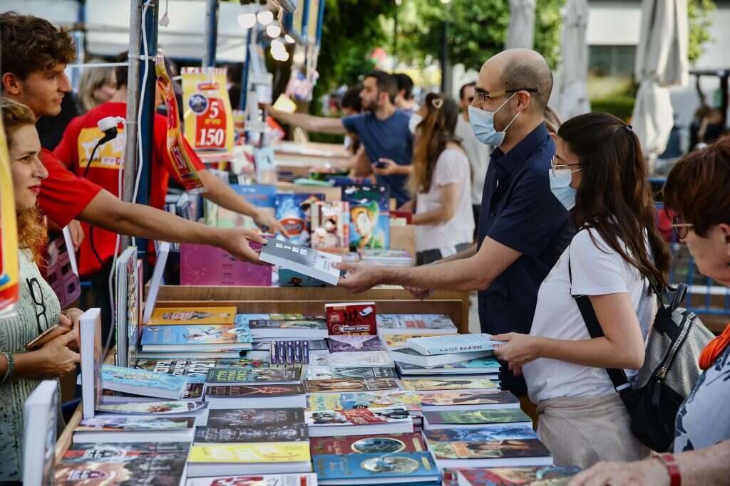 המוצר הכי נמכר בחנות הספרים הוא מטען לפלאפון. דוכני שבוע הספר. | יהושע יוסף המוצר הכי נמכר בחנות הספרים הוא מטען לפלאפון. דוכני שבוע הספר. | יהושע יוסף