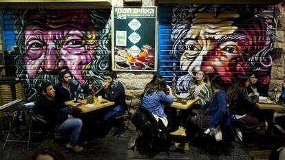 על רקע גרפיטי של הרב אברהם יהושע השל שיצר סולומון סוזה, שוק מחנה יהודה, 2016 . למצולמים אין קשר לנאמר בכתבה. | EPA