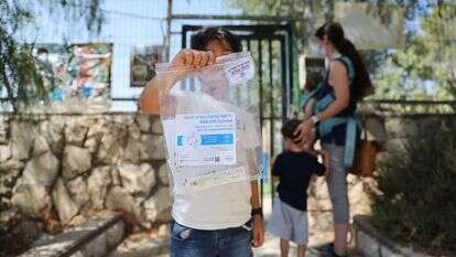 תלמיד מחזיק בדיקת קורונה מחוץ לבית ספר בירושלים. | EPA