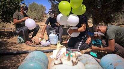 מחבלים ברצועת עזה מכינים בלוני תבערה לשיגור לישראל. | AFP