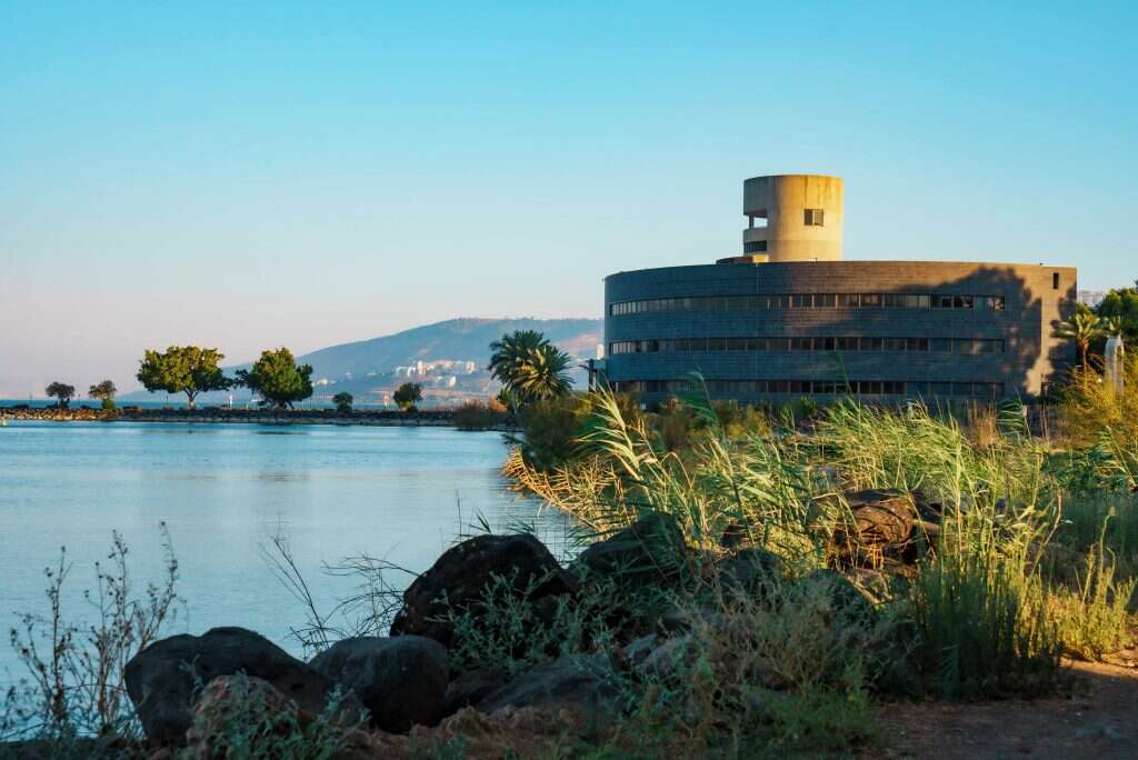 בית יגאל אלון על רקע הכנרת. | אנצ׳ו גוש - ג׳יני