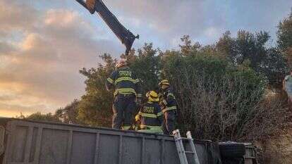כוחות הכיבוי וההצלה מנסים להפוך את האוטובוס כדי לחלץ את הגבר הלכוד תחתיו. | כיבוי אש