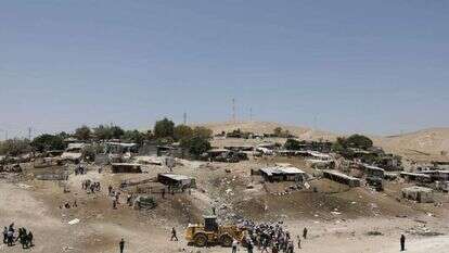 מפגינים פלסטינים מונעים מטרקטור לממש את
צווי ההריסה בחאן אל־אחמר, 4 ביולי 2018. | אי.פי.איי מפגינים פלסטינים מונעים מטרקטור לממש את
צווי ההריסה בחאן אל־אחמר, 4 ביולי 2018. | אי.פי.איי