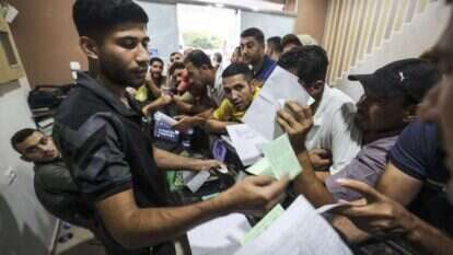 פועלים בעזה נרשמים לקבלת אישור עבודה בישראל. | AFP