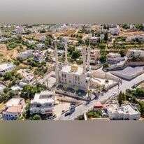 המואזין קרא לתושבים לבוא להתחסן. מסגד קדירוב באבו־גוש. | שאטרסטוק