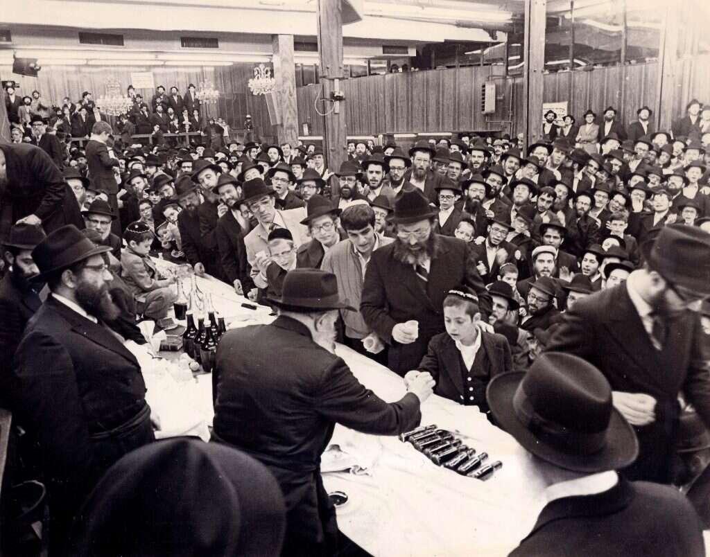 ג'ייקובסון כילד עם אביו בהתוועדות של הרבי מלובביץ'. | באדיבות המצולם