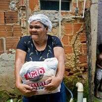 ריטה מריה דה-סוזה עם חבילת המזון שקיבלה. | AFP