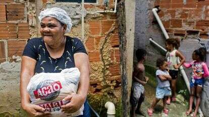 ריטה מריה דה-סוזה עם חבילת המזון שקיבלה. | AFP