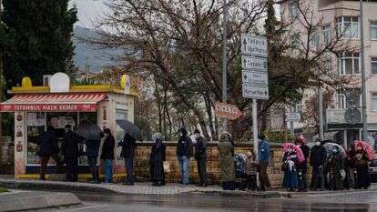 טורקים עומדים בתור לרכוש לחם במכולת. | AFP