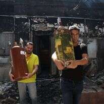 ספרי תורה מוצאים מבית כנסת שהוצת בלוד בזמן הפרעות. | איי.אף.פי