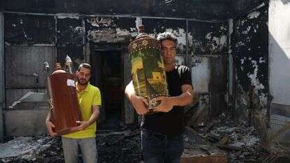 ספרי תורה מוצאים מבית כנסת שהוצת בלוד בזמן הפרעות. | איי.אף.פי