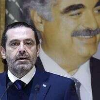 ראש ממשלת לבנון סעד אלחרירי מודיע על התפטרותו כשמאחוריו דיוקנו של אביו המנוח. | EPA