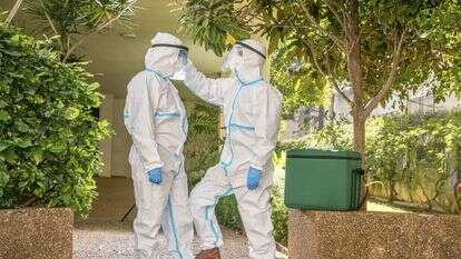 מתמגנים לפני הכניסה לבית החולה. | יוסי אלוני