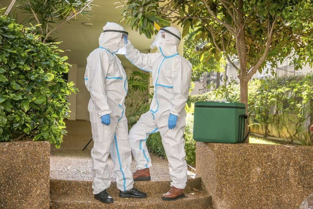 מתמגנים לפני הכניסה לבית החולה. | יוסי אלוני