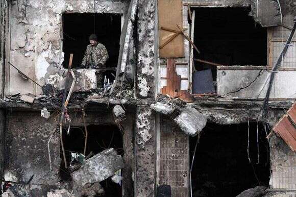 חייל אוקראינה עומד בבית הרוס במרכז קייב. | AFP