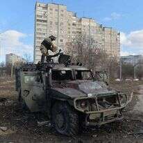 חיילים אוקראיניים עם משוריין רוסי שהופצץ. | AFP