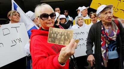 ניצולת השואה מלכה גורקה מחזיקה בתמונה מימי לימודיה בפולין במהלך הפגנה מול שגרירות פולין בתל־אביב נגד חוק השואה הפולני, 2018. | AFP