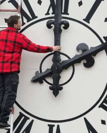 טכנאי מטפל בשעון על מגדל כנסייה בדרזדן, גרמניה | גטי אימג'ס