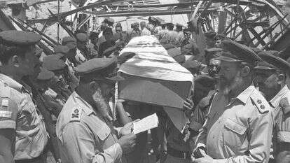 גולת הכותרת של מפעלו ההלכתי: התרת עגונות והבאת גופות חללי צה"ל לקבורה. הרב גורן אומר קדיש על נופלים מחיל האוויר בעת השבת גופותיהם, 1967. | אילן ברונאר, לע"מ