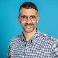 ניצול תאומי מנגלה מאוושויץ, צבי ויזל, אוחז בידו ספר תורה מימי השואה.