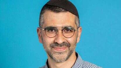 ניצול תאומי מנגלה מאוושויץ, צבי ויזל, אוחז בידו ספר תורה מימי השואה.