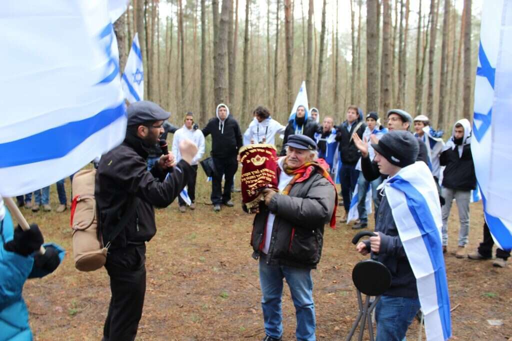 סמוך לקבר אחים ביער ליז'נקי. במרכז: ניצול השואה נתן וייס