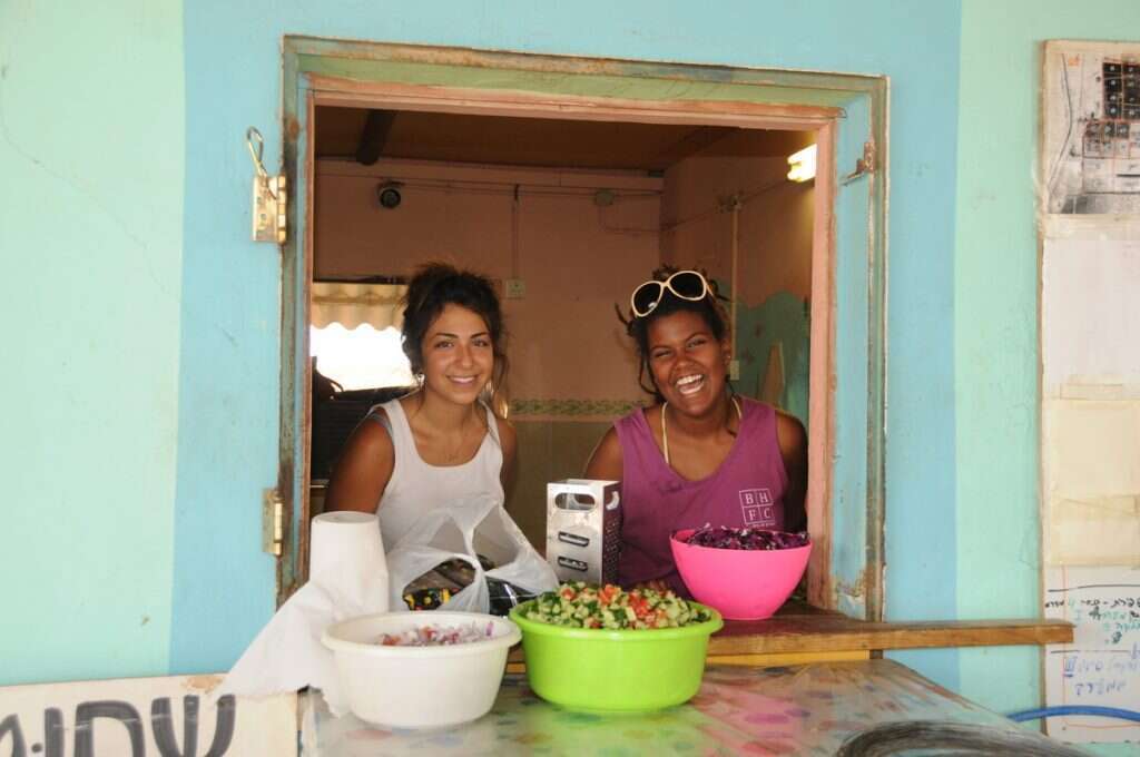 האידיאלים של רוסו, מרקס ובובר במאה ה־21. איילה סדן, (מימין) ומיקול אשכנזי מכינות אוכל לפועלים במטע התמרים. | רחל בנאי מתוך הסרט "כולם צ'יף - אין אינדיאנים"