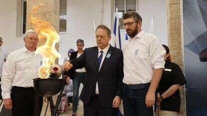 האח השכול אדוארד גרמן (מימין) והאב השכול גרמן רוז׳קוב (משמאל) מדליקים את לפיד הזיכרון יחד עם יו"ר ההסתדרות הציונית העולמית יעקב חגואל. | אוליבייה פיטוסי, הסוכנות היהודית