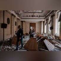 פקידי ממשל אוקראינים אומדים את הנזק שנעשה לבניין ממשלתי בחרקיב לאחר תקיפה רוסית. | AFP