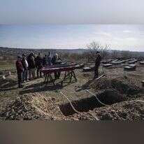 הרב אסמן אומר קדיש בהלווייתו של יהודי שנהרג בידי חיילים רוסים בבוצ'ה הסמוכה לקייב, בערב פסח. | AP