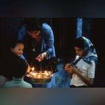 אם וילדיה מדליקים נרות בהילולת ל"ג בעומר בבית הכנסת אל־גריבה בתוניסיה, 1981. | יאן פאריק. באדיבות המרכז לתיעוד חזותי ע"ש אוסטר, אנו – מוזיאון העם היהודי