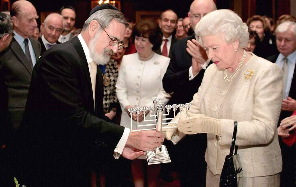 "הוא לא היה צריך לצעוק 'פגשתי את ההוא ואת ההוא". עם המלכה אליזבת השנייה בהדלקת נר חנוכה ב־ 2006. | גטי אימג'ס