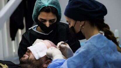 מאור בעת ביצוע ההשתלה. למטה: מסדרון מרפאת Hair Center Of Turkey שבאיסטנבול. | אנצ'ו גוש, ג'יני מאור בעת ביצוע ההשתלה. למטה: מסדרון מרפאת Hair Center Of Turkey שבאיסטנבול. | אנצ'ו גוש, ג'יני