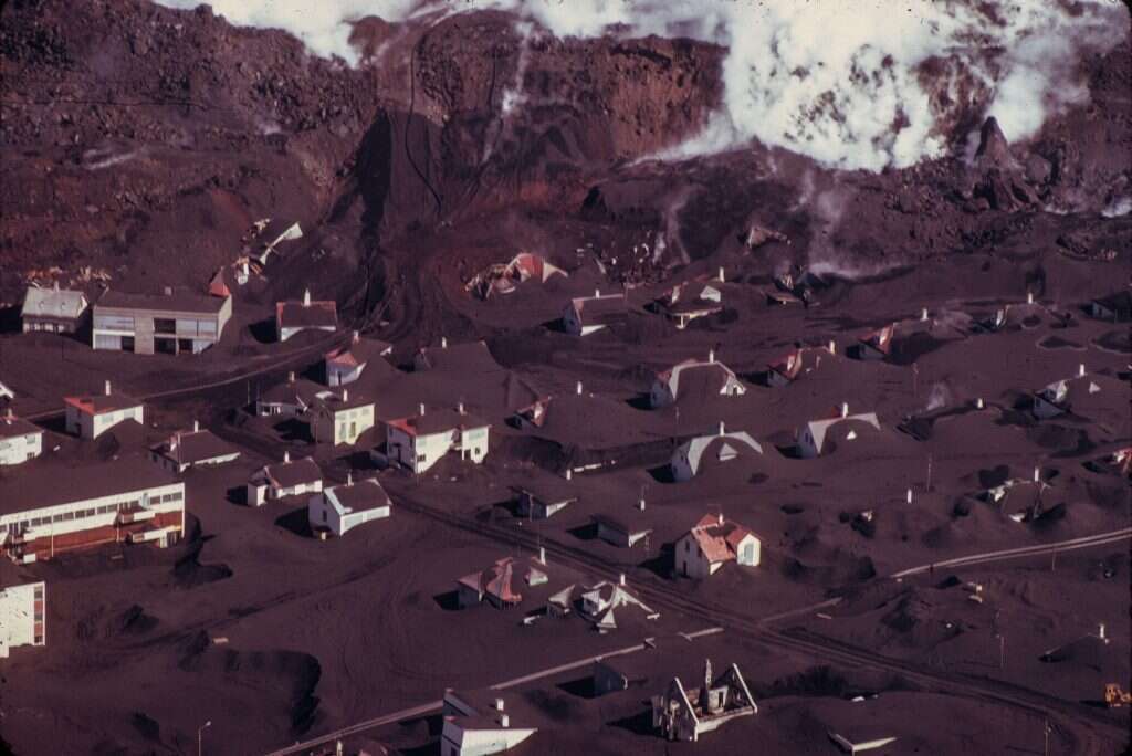 בתים באי היימאיי מכוסים אפר געשי, חודשים ספורים לאחר ההתפרצות ב־ 1973. | גטי אימג'ס