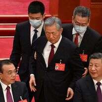 חו (עומד במרכז) מורחק מבימת הוועידה ה־20, בעוד שי (מימין) וראש הממשלה לי קצ'יאנג משתדלים להתעלם, בשבת. | איי.אף.פי