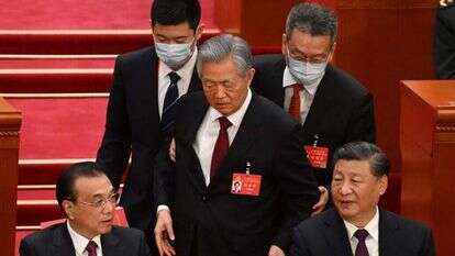 חו (עומד במרכז) מורחק מבימת הוועידה ה־20, בעוד שי (מימין) וראש הממשלה לי קצ'יאנג משתדלים להתעלם, בשבת. | איי.אף.פי